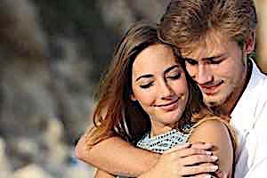 Smiling man with arm around smiling woman