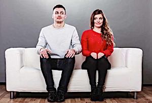 shy man and woman sitting on a couch