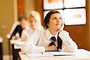 girl sitting at school desk daydreaming about boyfriend