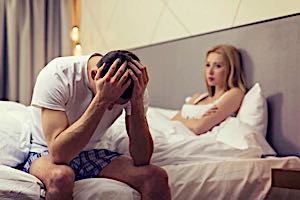 frustrated man in bed next to upset woman