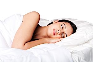 a woman in bed happy dreaming with smile on face