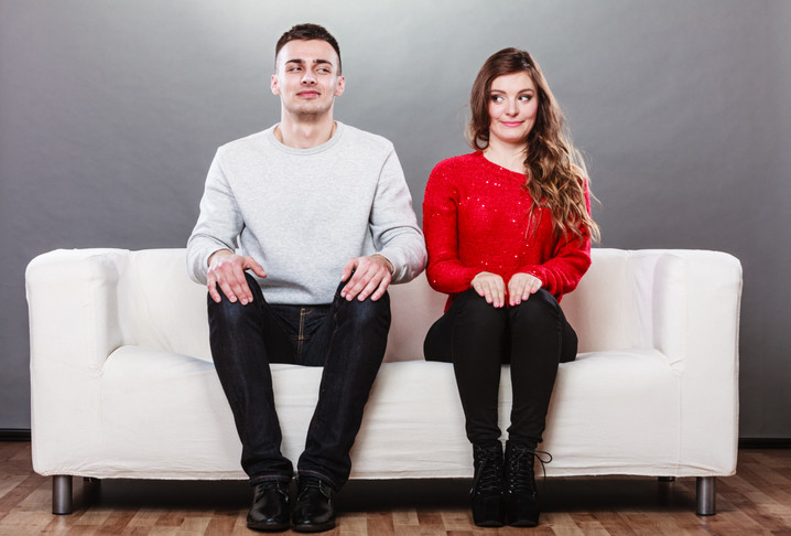 man and woman on couch thinking about dating each other