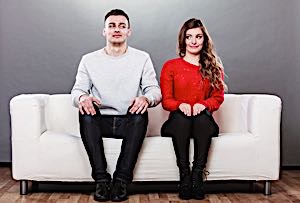 man and woman on couch thinking about dating each other