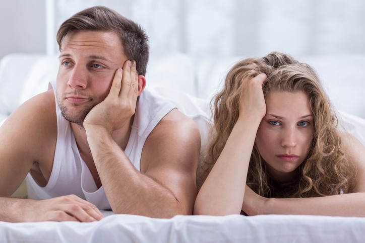 man and woman in bed ignoring each other