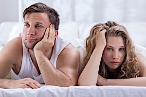 man and woman in bed ignoring each other