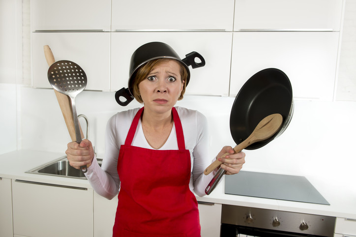 confused housewife wearing cooking pot on head