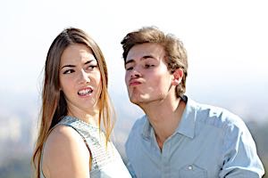 Disgusted woman avoids a kiss