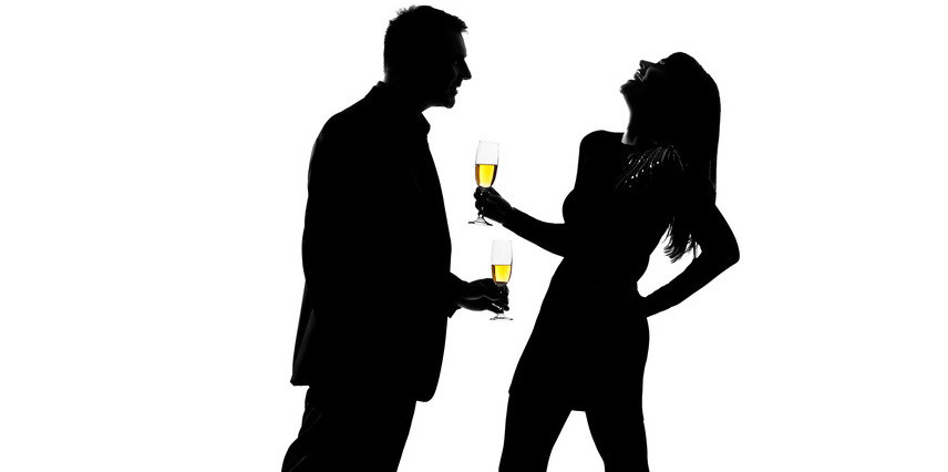 unfaithful man and woman holding drinks and laughing at a party