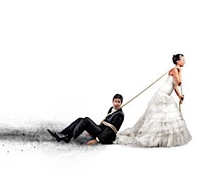 woman in wedding gown dragging man to alter