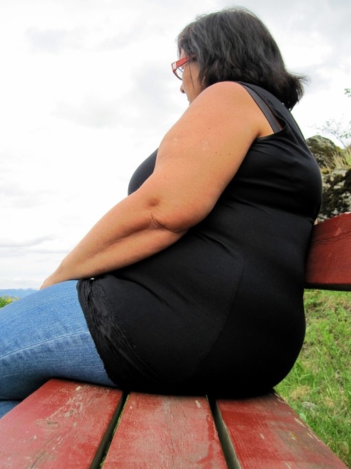 obese woman sitting on park bench