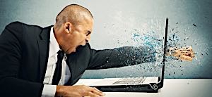 angry man punching fist through computer screen