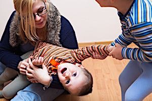 Man and woman trying to control young squirming boy