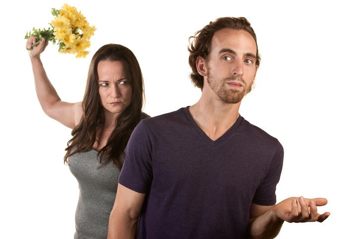 angry woman throwing flowers at puzzled man