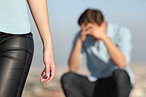 man sits with head in hands as his wife walks away