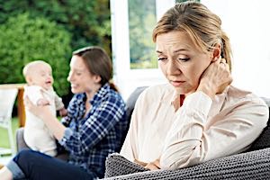 sad childless woman near happy mom and baby