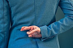 man standing with fingers crossed behind his back