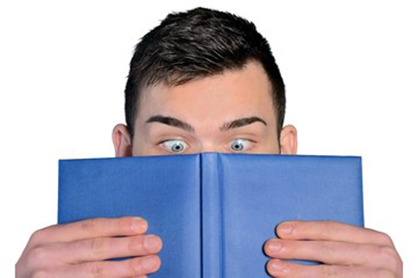 guilty man sneaking a peek at a book